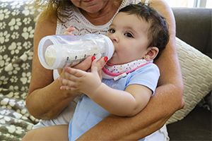 A woman feeding a bottle to a baby